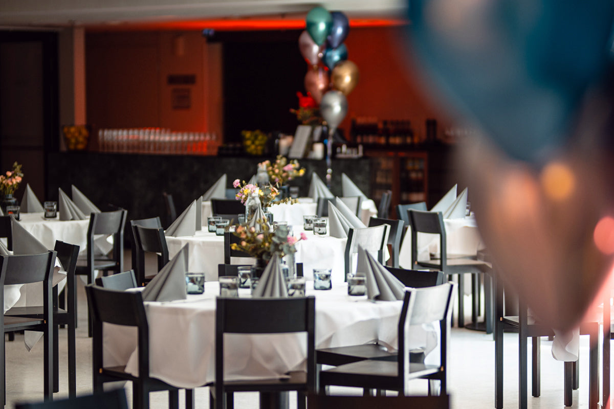 Ravintola Domuksen juhlatila, jossa pöydät ovat katettu ja tila on koristeltu ilmapalloilla. 