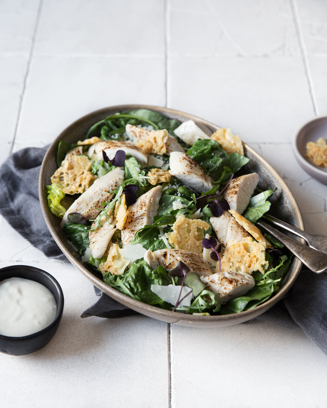 Caesar-salaattia kanalla ja parmesanilla tarjoilulautasella. 