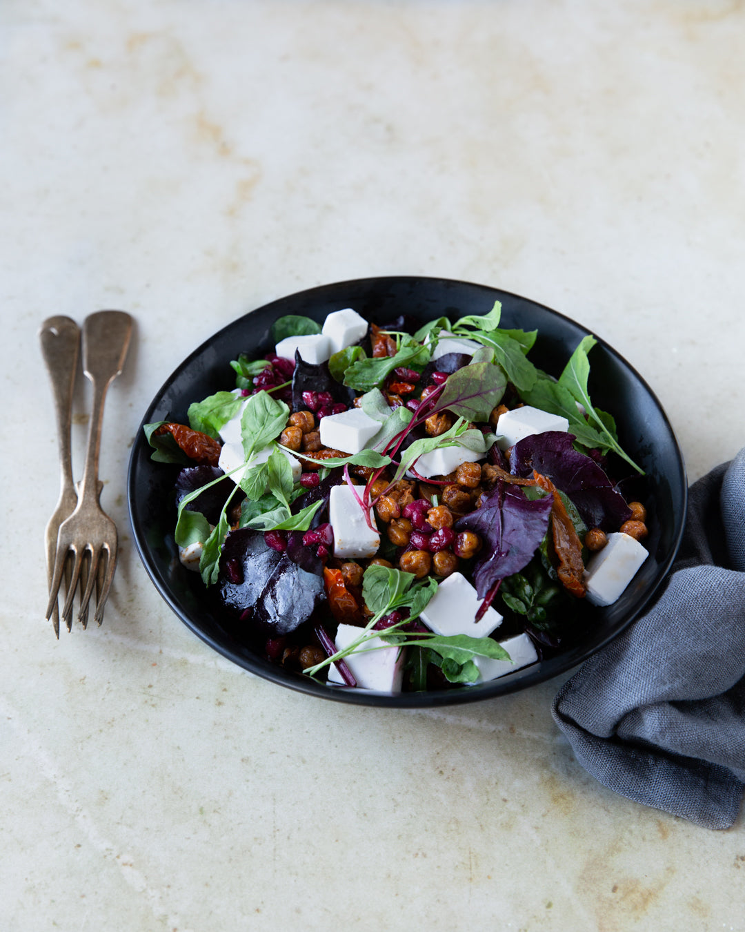 Salaattia paahdetusta kikherneestä ja vegaanisesta fetasta lautasella. 