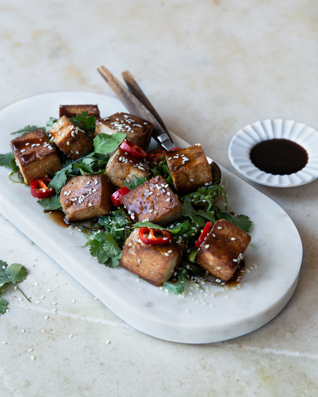 Seesamtofua wakame-salaatilla tarjoilulautasella. 