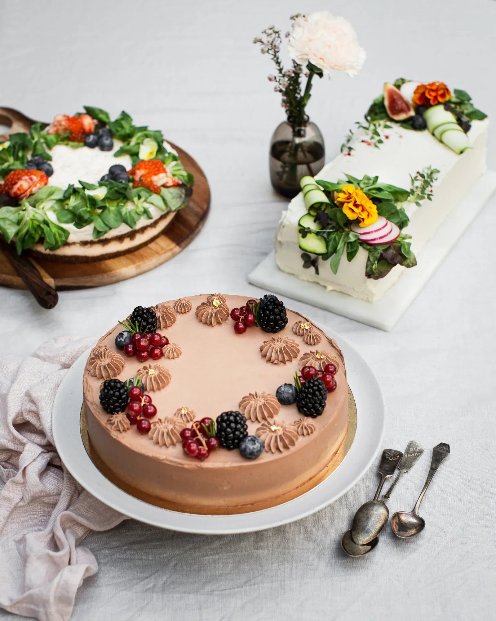 Juhlava kattaus suklaisella juustokakulla, voileipäkakulla ja suolaisella piirakalla. 