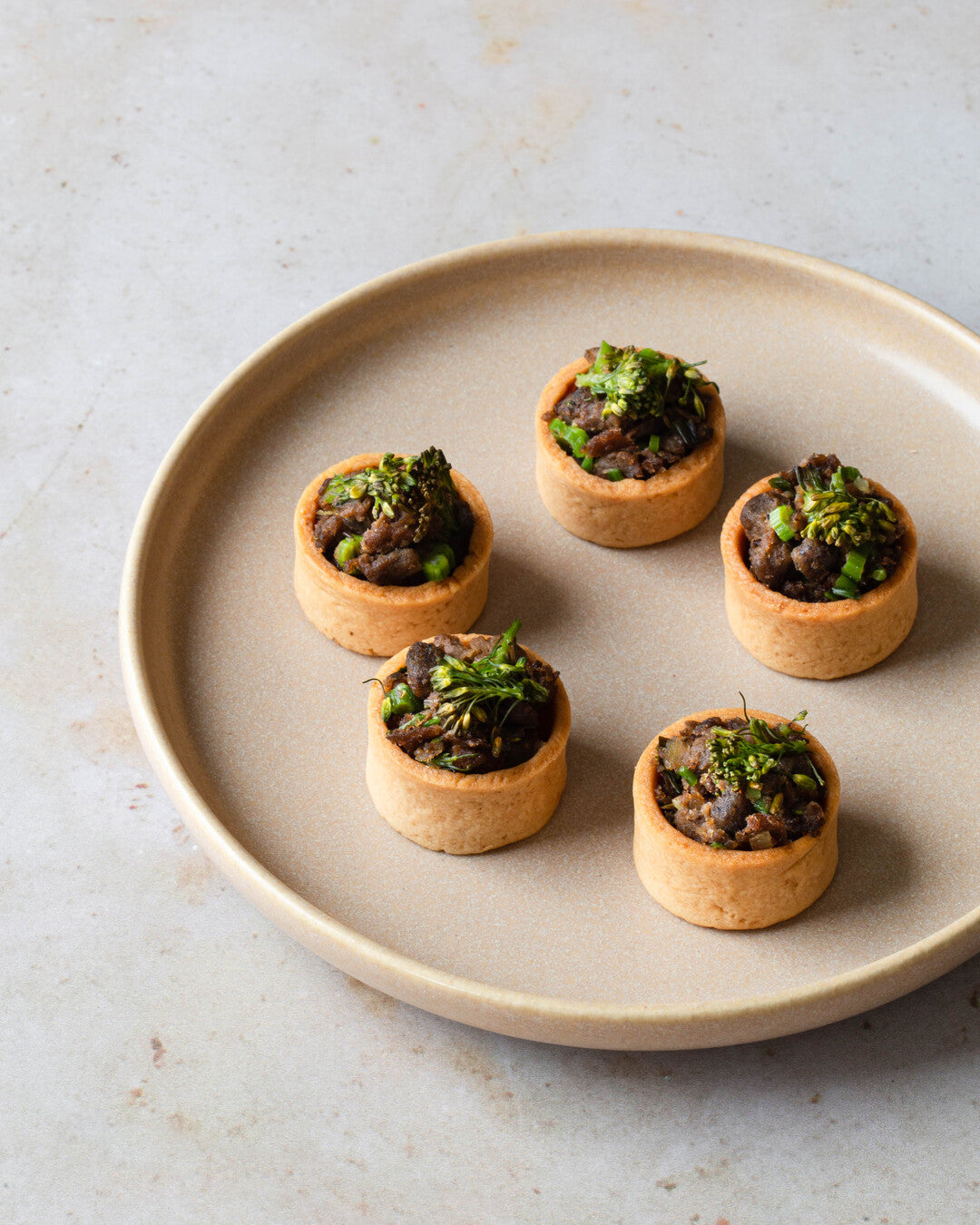 Broccolia, seesamhärkäpapua ja hummusta vohvelikorissa - cocktailpalat lautasella.