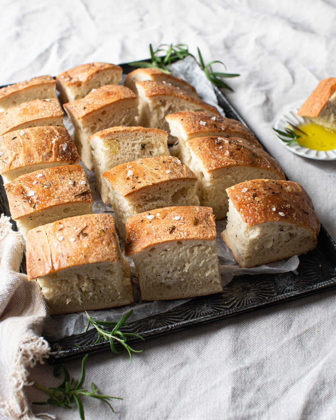 Runsas paloiksi leikattu luomufocaccia uunipellillä.