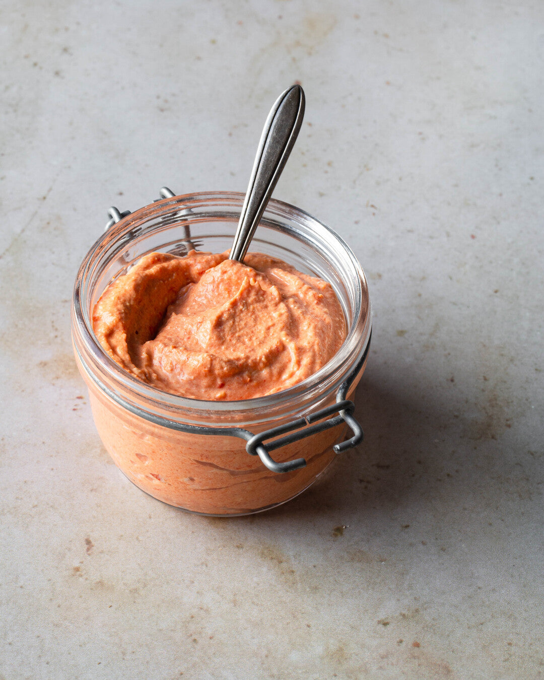 Paprika-fetajuustolevite lasipurkissa.