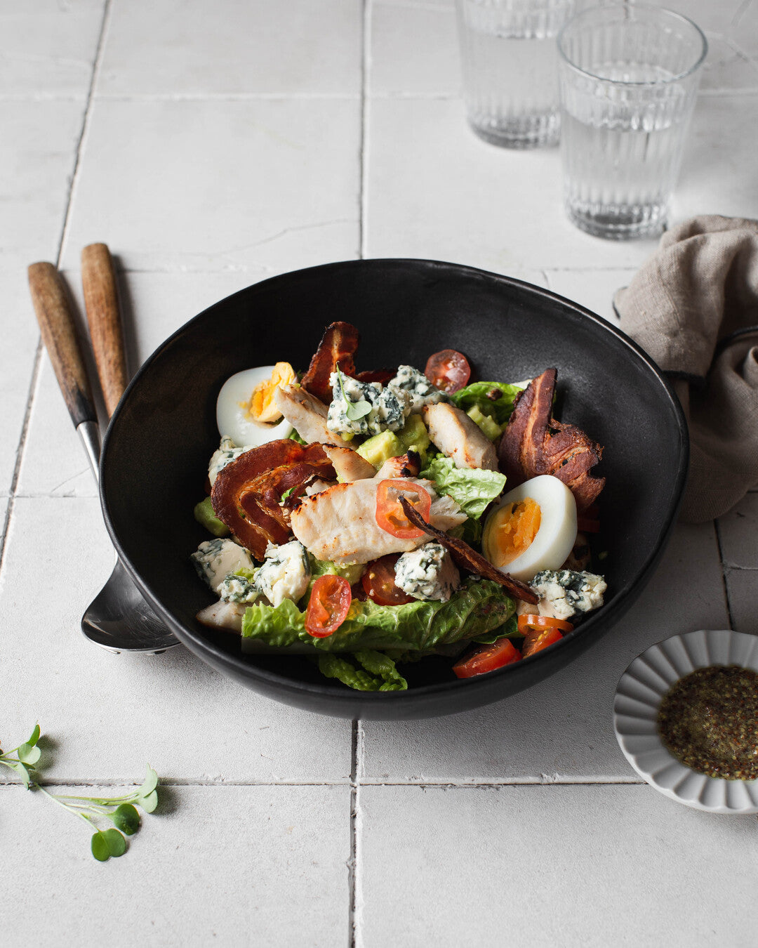 Cobb-salaattia kanalla ja pekonilla tarjoiluastiassa katetulla juhlapöydällä.