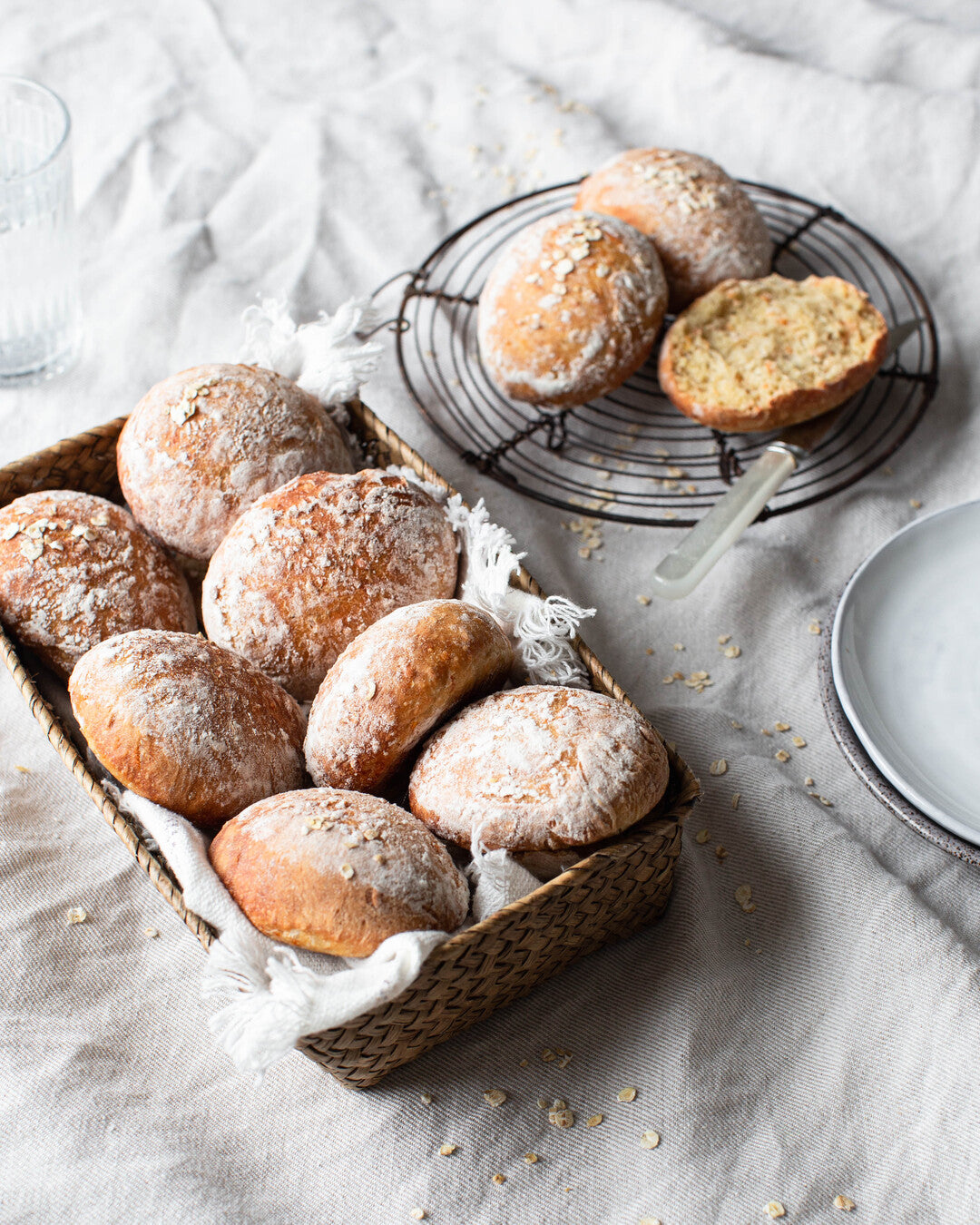 Käsin leivottuja, tuoreita luomuporkkanasämpylöitä korissa.