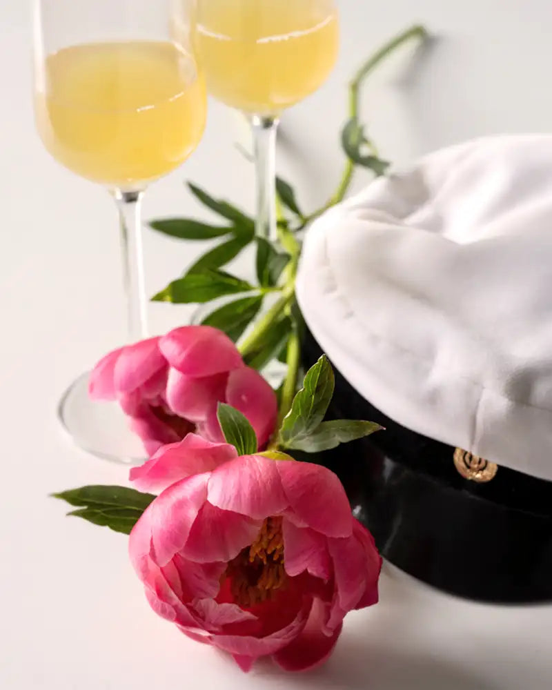 Ylioppilaslakki, pioneja ja kaksi kuohuviinilasia. 